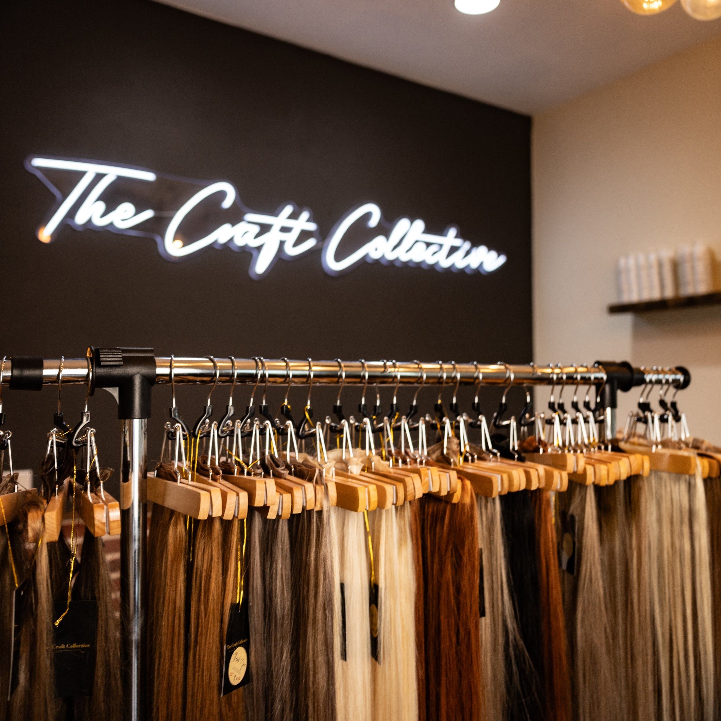 Hair extensions on display under The Craft Collective neon sign