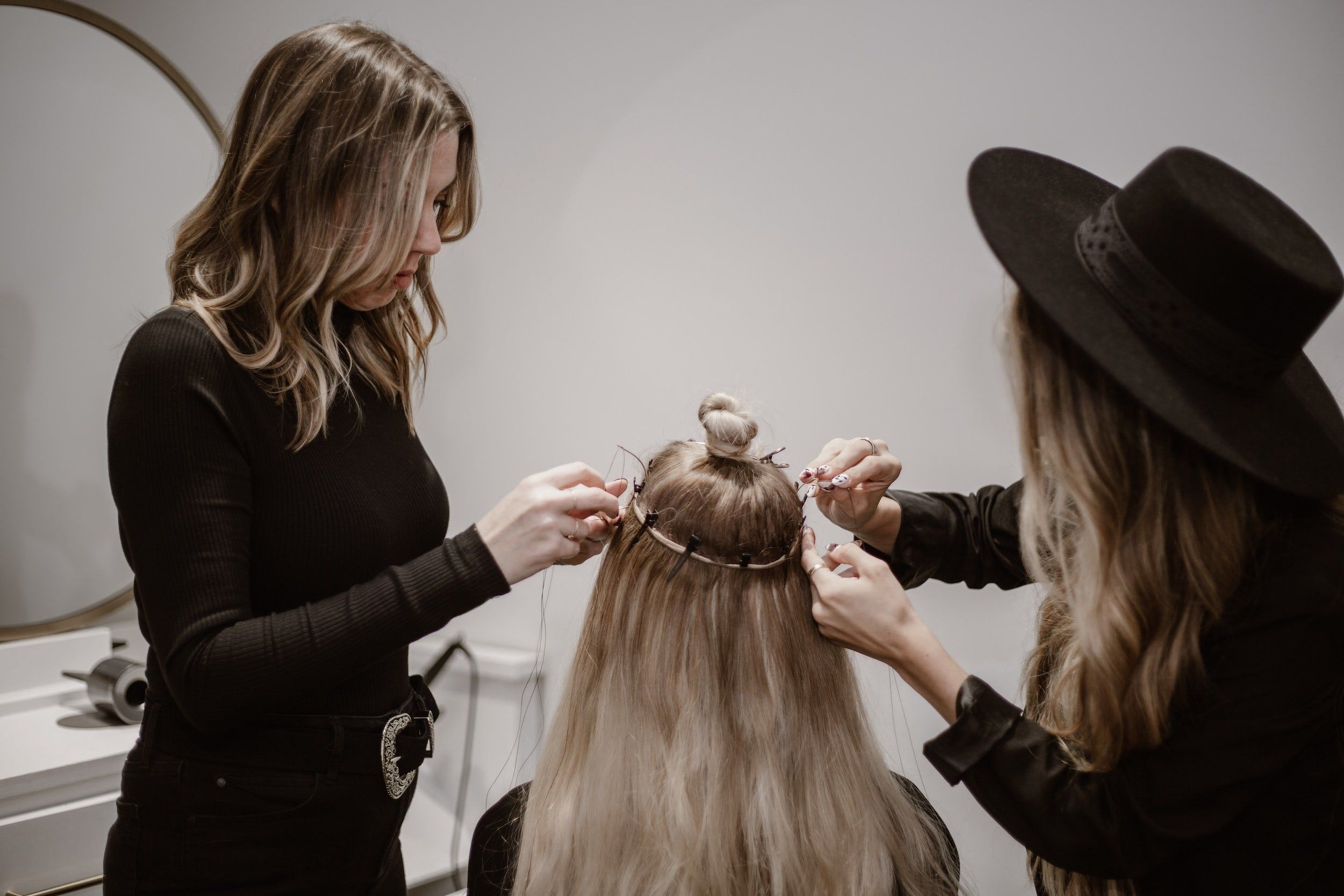 Stylists installing hair extensions