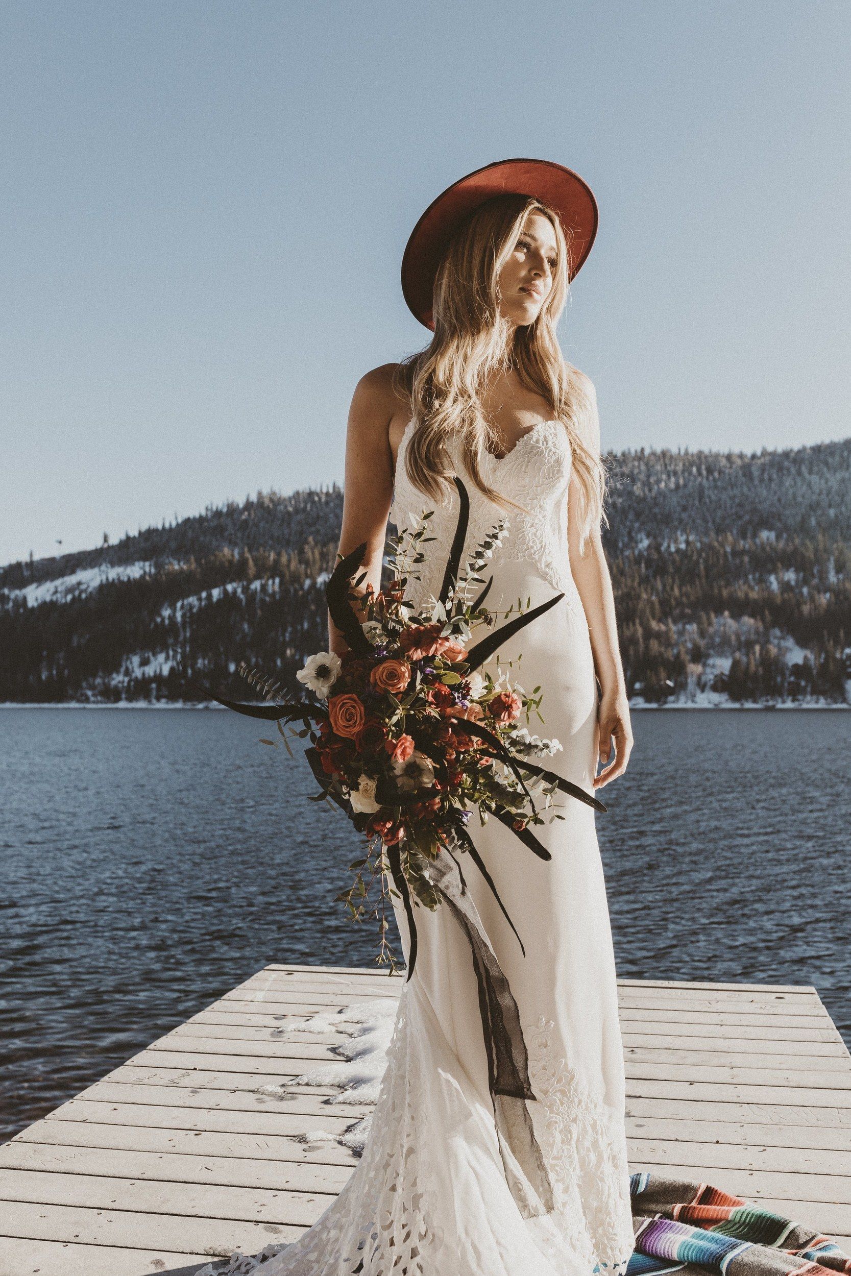 Bride in a hat on a lake dock in winter